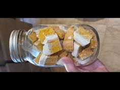 a person holding a jar filled with marshmallows