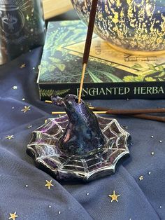 an incense stick sitting on top of a glass bowl next to two bookends