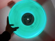 a person pointing at a glowing disc with the word wnves written on it