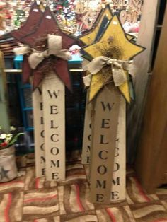 two wooden stars with bows on them sitting next to each other in front of a store