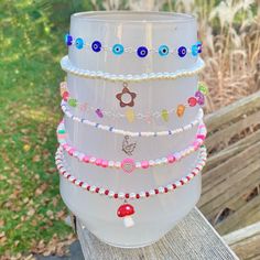 a stack of bracelets sitting on top of a wooden table next to a grass field