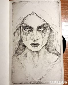 a drawing of a woman's face in black and white ink on a piece of paper