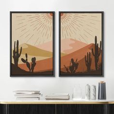 two framed art prints on the wall above a console table with books and vases