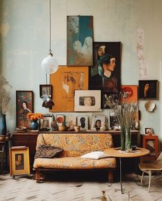 a living room filled with furniture and pictures on the wall next to a coffee table