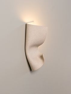 a white wall light mounted to the side of a wall