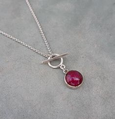 Minimalist ruby toggle necklace,ruby birthstone necklace,anniversary wife gift,ruby chocker Natural round 10mm opaque ruby cabochon set in a sterling silver bezel with a sterling silver cable chain It's simple and minimalist can be worn alone or layered with other necklaces The ruby is july birthstone, great birthday/anniversary wife gift for ruby lovers:) Measures : Ruby- 10mm Necklace length- please select Door to door shipping Ruby Cabochon Round Jewelry, Minimalist Ruby Jewelry As A Gift, Minimalist Ruby Jewelry As Gift, Gift Jewelry With Sterling Silver Clasp Round Pendant, Gift Round Pendant Jewelry With Sterling Silver Clasp, Ruby Cabochon Pendant Jewelry, Handmade Silver Toggle Necklace For Gift, Sterling Silver Necklace With Toggle Clasp As Gift, Sterling Silver Toggle Necklace Gift