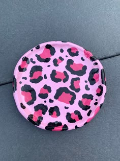 a pink and black leopard print paper plate on the ground with one piece cut out