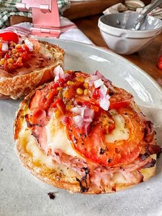 two open faced sandwiches on a plate with tomatoes and other toppings, ready to be eaten