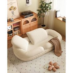 a living room filled with furniture and a potted plant on top of a rug