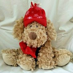 a stuffed dog with a red hat and scarf on it's head sitting in front of a white background