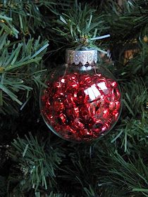 a red ornament hanging from a christmas tree