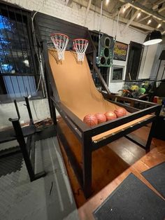 an indoor basketball court made out of cardboard and some basketballs on the ground in front of it