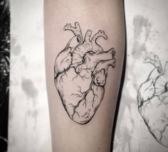 a black and white heart tattoo on the arm