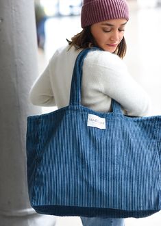 a woman carrying a blue tote bag