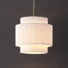 a white light hanging from a ceiling fixture in a room with dark walls and flooring