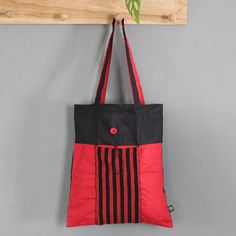 While this red and black tote bag is spacious enough for carrying your shopping bags or your travel essentials, it can also be folded to the size of a clutch bag for storage purposes. Handy reasons aside, the bag is hand-woven from cotton by the Lawe Lurik Community in Java, featuring a stylish aura thanks to its vibrant hues and the classic Indonesian lurik striped pattern on the exterior pocket, which comes with a button closure that allows for folding. Eco-friendly Red Shoulder Bag For Shopping, Trendy Red Canvas Gift Bag, Eco-friendly Red Tote Shoulder Bag, Red Eco-friendly Canvas Shopping Bag, Trendy Red Gift Bag, Eco-friendly Red Everyday Bag, Eco-friendly Red Tote Bag, Eco-friendly Red Canvas Bag For Daily Use, Eco-friendly Red Shopping Bag