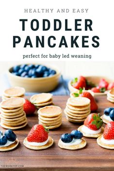 toddler pancakes with strawberries and blueberries in the middle on a cutting board