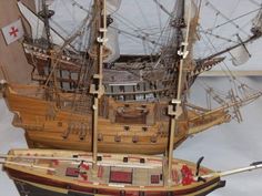 a wooden model of a sailing ship on display