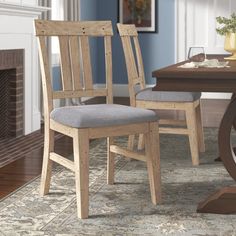 a dining room table with two chairs and a rug