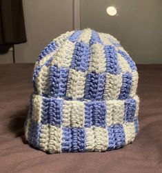 a blue and white hat sitting on top of a bed