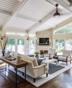 a living room filled with furniture and a flat screen tv mounted on the wall above a fireplace