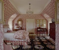 a bedroom with pink and gold wallpaper, chandelier and bed in it