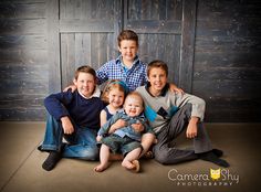 a family posing for a photo in front of a wooden wall