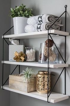 two shelves with towels, candles and other items on them in a home office area