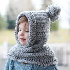 a young child wearing a gray knitted hat and scarf