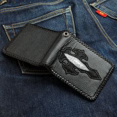 a pair of jeans with a fish patch on the back pocket and a black leather wallet