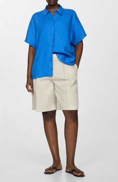 Stay cool throughout the warmer seasons in this lightweight linen button-up perfected by short sleeves and a modern boxy fit. Front button closure Point collar Short sleeves 100% linen Machine wash, line dry Imported Summer Tops In Flax Color With Button Closure, Flax Top With Button Closure For Summer, Summer Flax Tops With Button Closure, Summer Workwear Tops In Flax Color, Short Length Linen Tops With Pockets, Linen Tops With Pockets, Short Length, Short Linen Tops With Pockets, Mango Shorts, Ink Blue