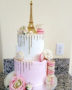 a pink and white cake with the eiffel tower on top