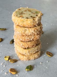 five cookies stacked on top of each other with pistachio seeds scattered around them