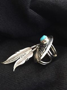 This is a beautiful unique sterling concho ring with a bezel set turquoise and two dangling feathers. One of the most unique features is how the is how the bands or shank on the ring is constructed in a double type wrap. I acquired three rings with this unique style shank of which one is signed BJ, from a local estate. Ring size 4 but feels tighter because of the shank style. Dimensions: 2 1/2 inches from the top of the concho to the tip of the longest feather. Concho is 1 5/8 inch across. Turqu Adjustable Turquoise Jewelry With Feathers, Travelers Rest Sc, Dangle Ring, Travelers Rest, Estate Ring, Three Rings, Unique Features, Bezel Setting, Ring Gift