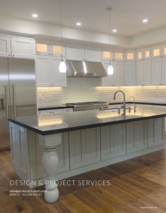 a large kitchen with white cabinets and black counter tops, an island in the middle