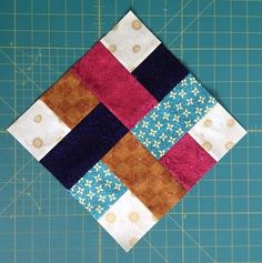 a piece of fabric that has been made into a patchwork quilt on top of a cutting board