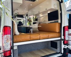 the back end of a white van with brown leather seats