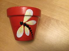 a painted flower pot sitting on top of a wooden table