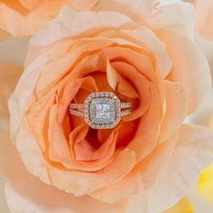 a diamond ring sitting on top of a flower