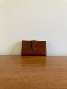 "This is an absolutely delightful vintage ladies wallet. Made of boxette calf, the leather is smooth and durable and is such a gorgeous and rich shade of brown. The kiss-lock closure is brass and opens to a coin purse. The accenting brass piece on the snap closure is a nod to mod and opens. to an elongated 2 part card sleeve. This side opens to a slot for bills. It's in terrific condition and measures approximately 6\"x4\" when closed.  Want to see more awesome vintage accessories? Visit the Ladies section of my shop here: https://www.etsy.com/ca/shop/LotusRoadVintage?ref=seller-platform-mcnav%C2%A7ion_id&section_id=27662622 Please visit my shop to see more gorgeous quality vintage items for your modern home: https://www.etsy.com/ca/shop/LotusRoadVintage?ref=seller-platform-mcnav" Vintage Wallet, Wallet Vintage, Ladies Wallet, Ladies Accessories, Card Sleeve, Clip Wallet, Money Clip Wallet, Vintage Accessories, Vintage Leather