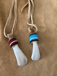 two toothbrushes with beaded handles on a brown carpeted surface, tied together