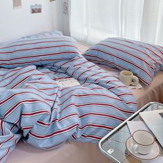 a bed covered in blue and red striped sheets