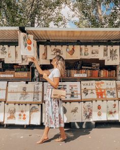 a woman standing in front of a book stand