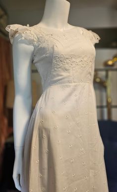 This is an amazing vintage Saks Fifth Ave Dress. It would make a beautiful Boho Wedding dress or a dress for a beautiful summer day.  It still has the dress order tag and is unworn. It has beautiful eyelet Floral lace on the skirt portion. The upper bodice has a larger cut out floral design. It is cotton and is lined.  There is a back nylon zipper and eyehook. The condition of dress is excellent, the only thing is, it's missing the belt. The dress is a maxi and is a size 4. Please see measurements to ensure a proper fit. Bust: 32" Waist: 24" Length: 55" This dress is pre-loved, as is. Thanx for checking out my shop. Have an awesome day, eh! (I multi-ship. Any shipping overages will be reimbursed). Vintage Cream Tea Length Dresses, Feminine Vintage Summer Wedding Dress, Vintage Cream Tea-length Dresses, Summer Wedding Vintage Dress In Feminine Style, Vintage Midi Dress For Wedding, Feminine Cream Vintage Dress For Wedding, Cream Vintage Midi Dress, Vintage Midi Wedding Dress With Fitted Bodice, Vintage White Summer Wedding Dress