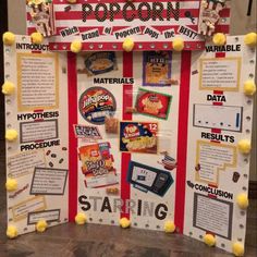 a bulletin board is decorated with candy bars, cereal bar signs and pom poms