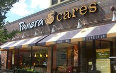 the front of a store with awnings on it's sides and windows