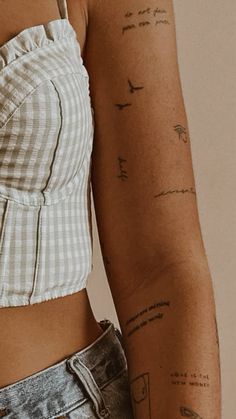 a close up of a person with tattoos on their arms and shoulder, wearing jeans