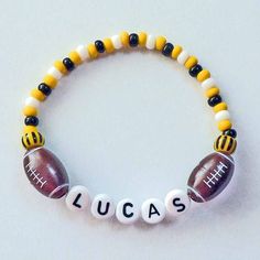 a beaded bracelet that says lucas with footballs on it