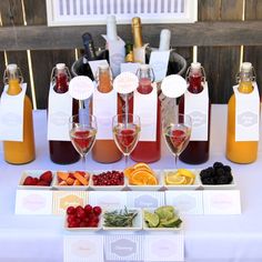 a table topped with bottles of wine and glasses filled with fruit