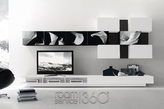 a modern white living room with black and white artwork on the wall above it, along with an entertainment center